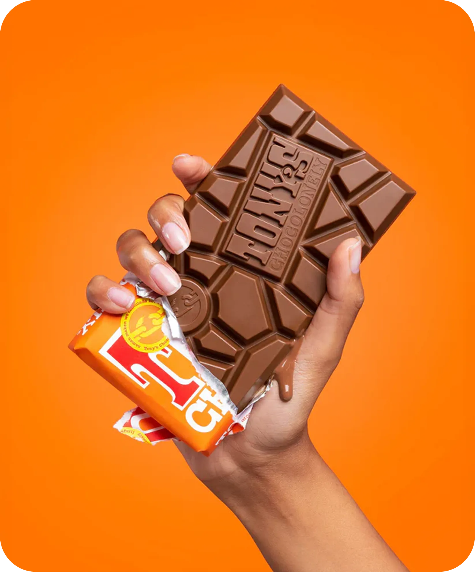 Hand met een smeltende chocoladereep in een oranje verpakking.